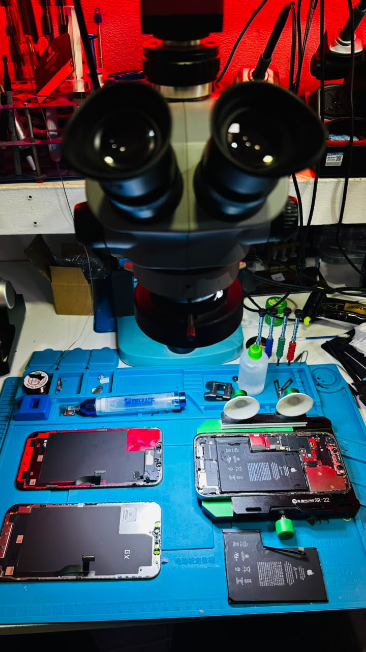Microscopio y celulares en banco de reparación